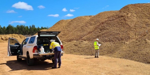 Two scientists investigating treated gravel stockpiles