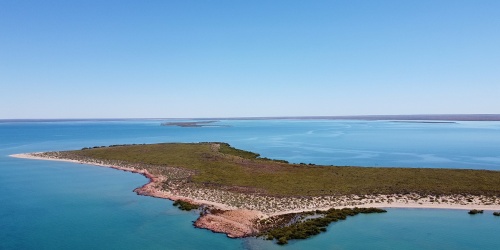 Aeriel image of Exmouth gulf with blue water and sky surrounding it