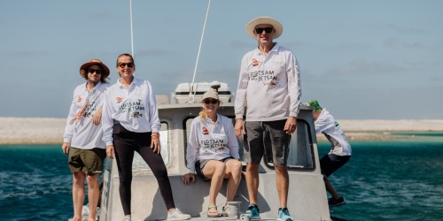 Flotsam and Jetsam volunteers on the boat MISS PIA 2, smiling at the camera