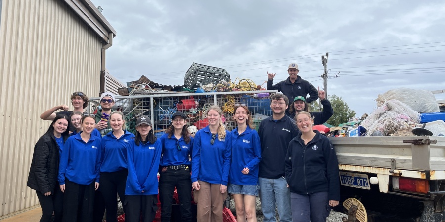 A group of people standing next to a ute full of marine debris