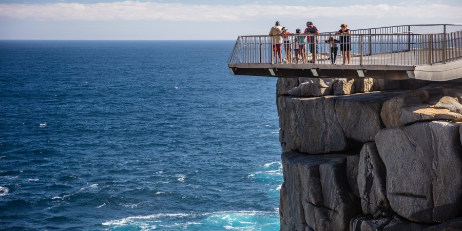 People looking out from a cliff-top viewing platform