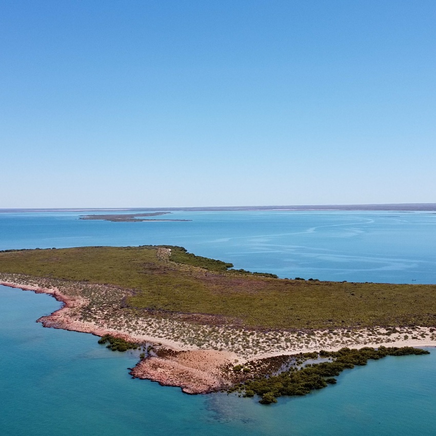 Aeriel image of Exmouth gulf with blue water and sky surrounding it