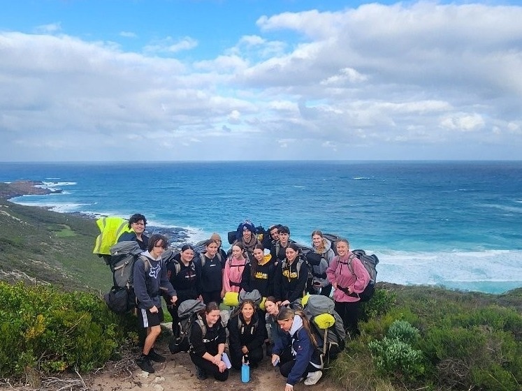Group of students on a track with ocean in the background
