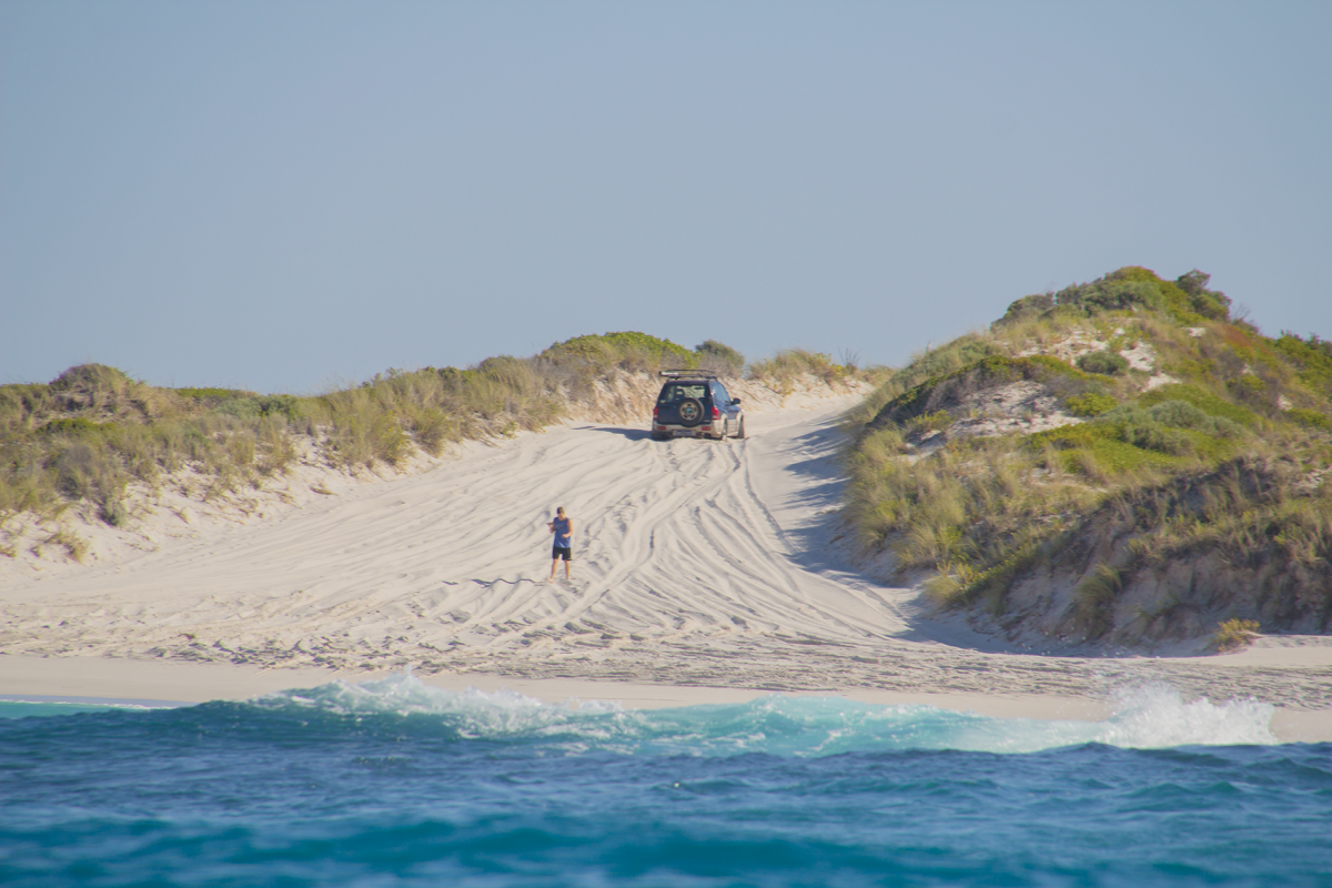 Image of four-wheel drive vehicle driving along the sand dunes