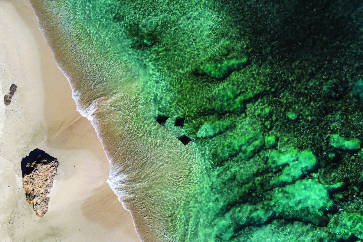 Aerial photo of waves crashing on shoreline