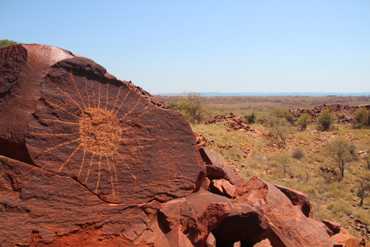 Circle and radiating lines geometric motif on the Southern Burrup with a high contrast state. Photo – Amy StevensMurujuga Aboriginal Corporation