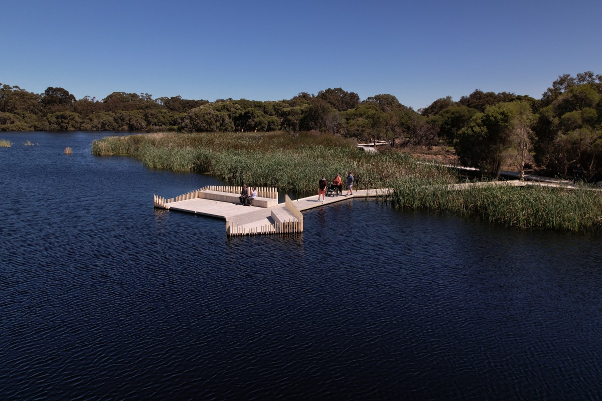 The boardwalk on the water with people walking on it