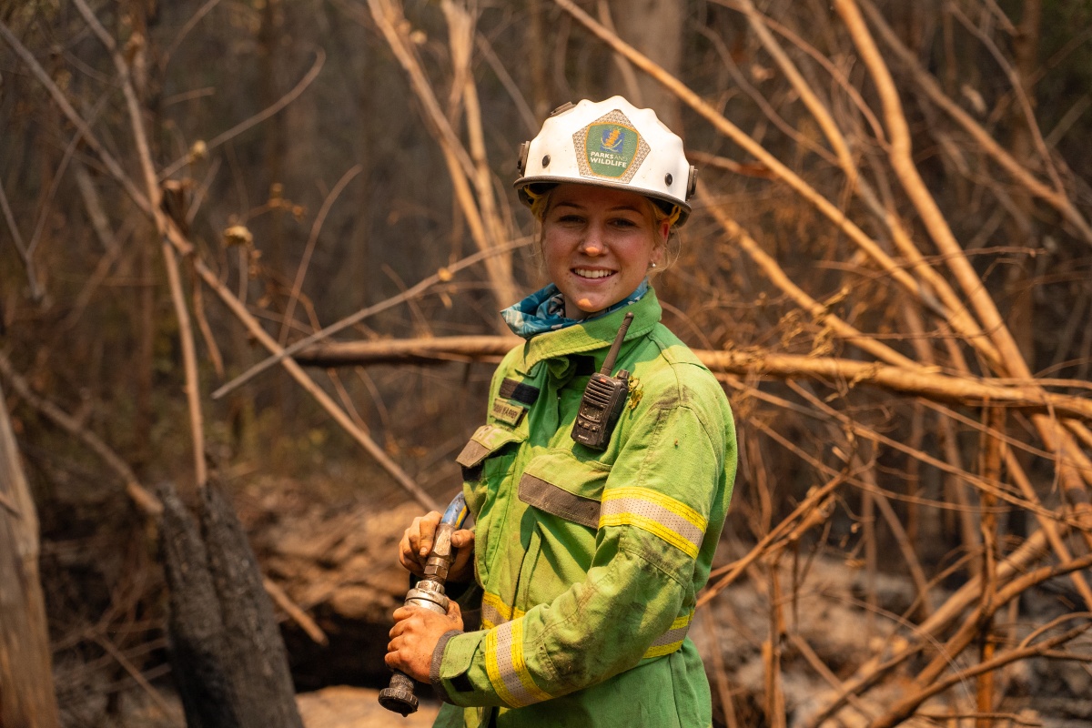 A female fire fighter smiles at the camera