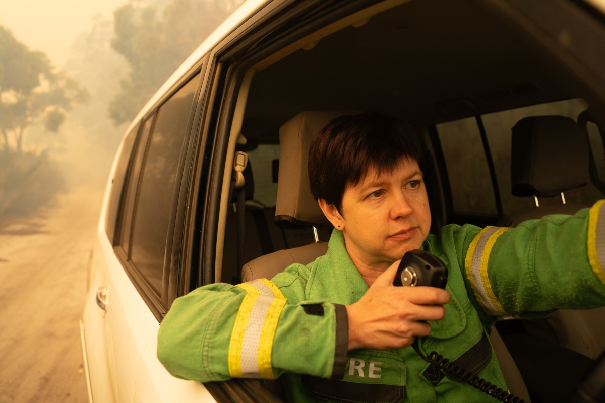 A female firefighter uses the radio in the car
