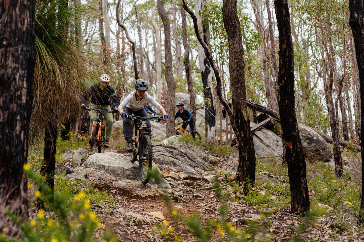 Trail bike riders coming down a rough track. Photo by Flow Mountain Bike