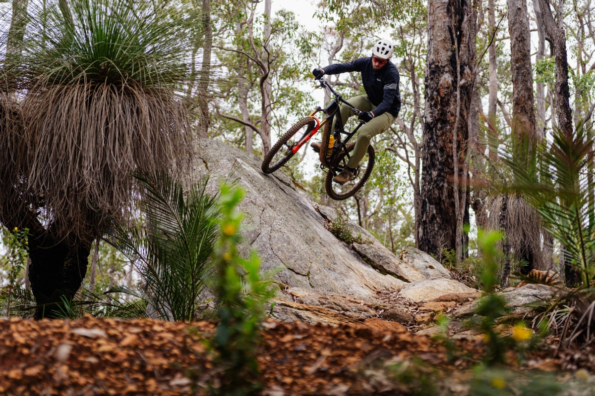 Trail bike rider going over bumps on dirt track