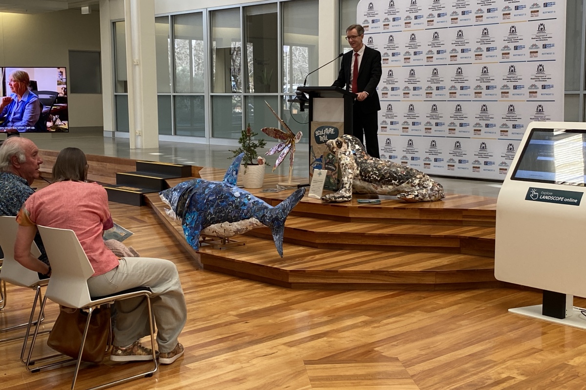 A man stands on a stage addressing an audience