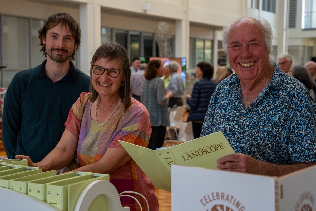 Two men and one woman smile at the camera