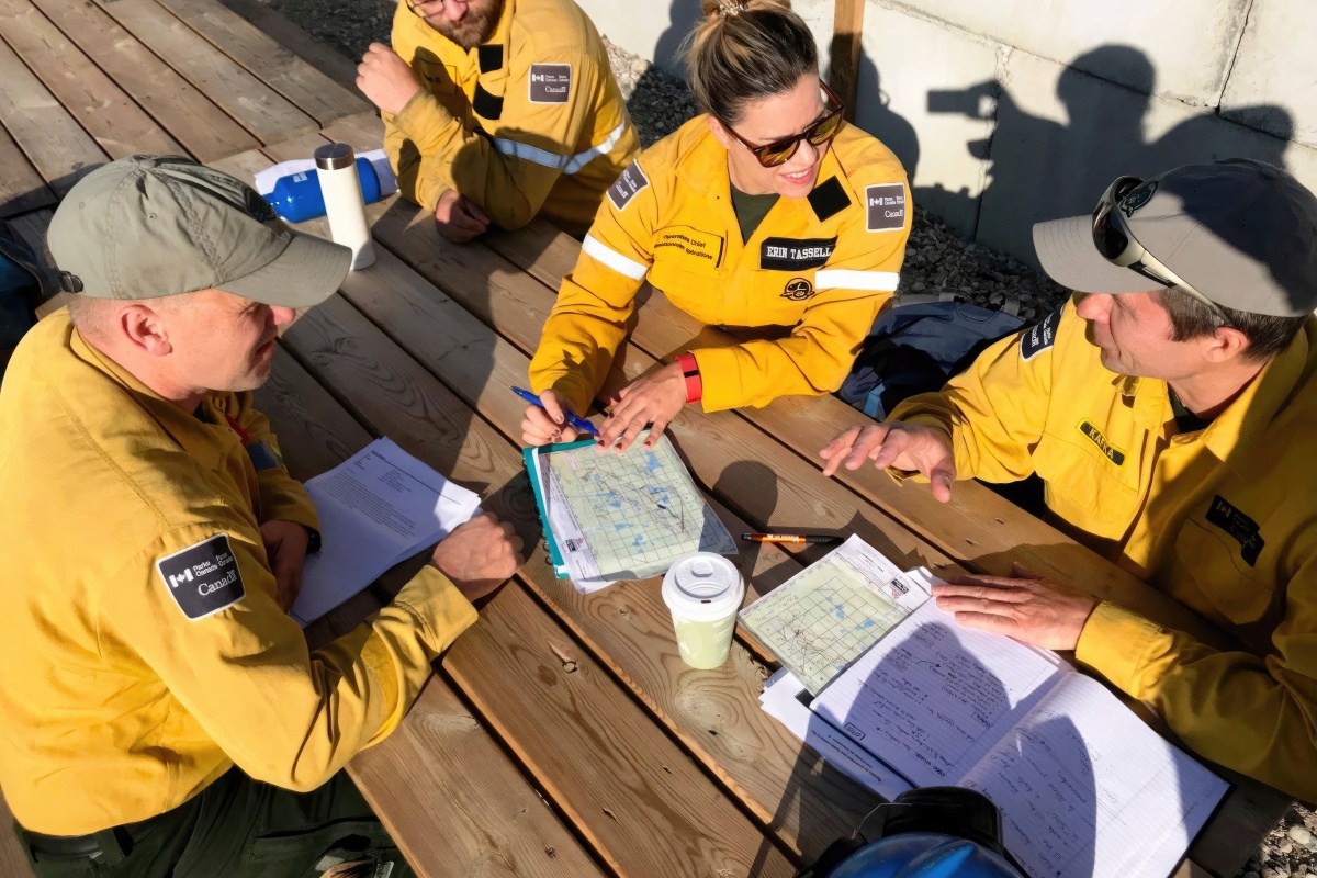 A team of people in firefighting gear meet around a table